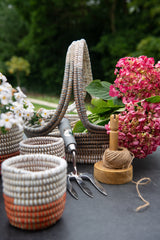 Decorative garden tools and pots with flowers on a table outdoors