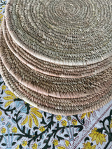 Set of woven placemats on a patterned tablecloth