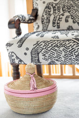 Woven basket with pink trim on a chair