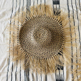Woven placemat with fringes on a striped fabric background