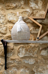 Decorative woven basket on a stone wall with a shelf