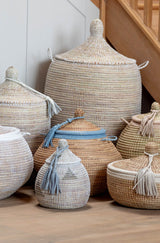 Set of woven baskets with lids on a wooden floor