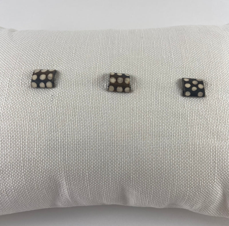 White Linen Cushion with African Sourced Buttons. The Os de Chameau cushion.