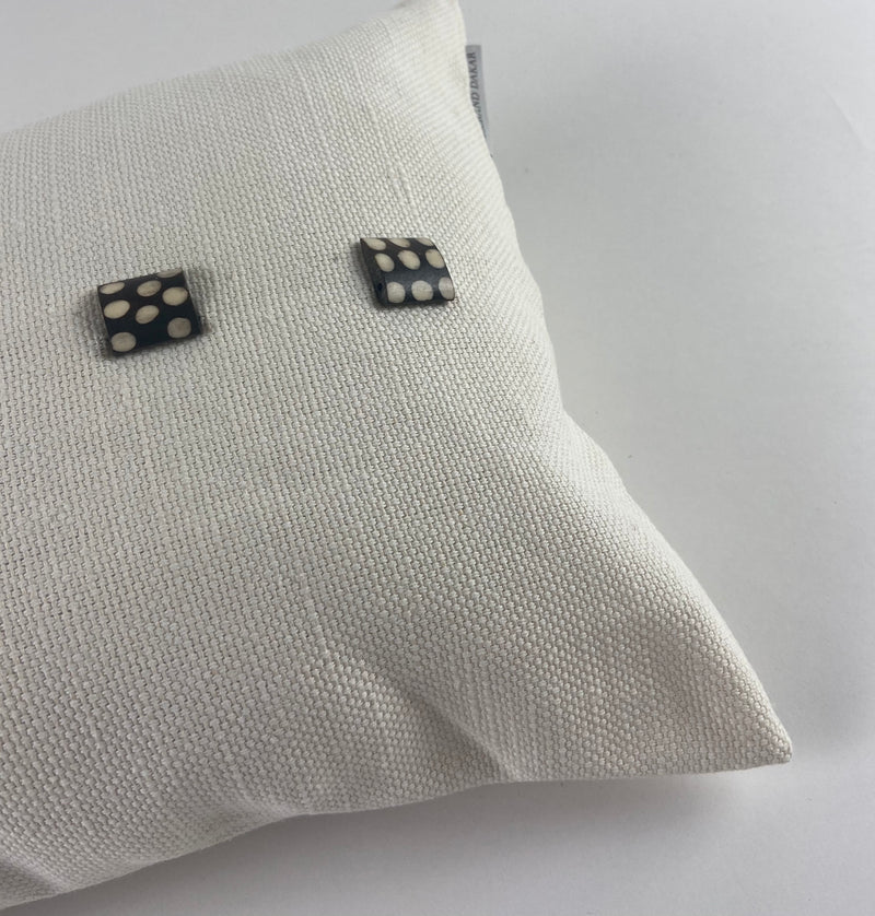 White Linen Cushion with African Sourced Buttons. The Os de Chameau cushion.