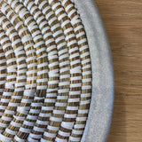 close up of handwoven white placemat with brushed silver trim detail