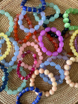 Colorful beaded bracelets on a woven surface