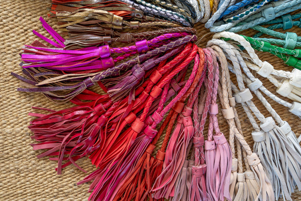 Colorful tassels arranged in a circular pattern on a textured surface.
