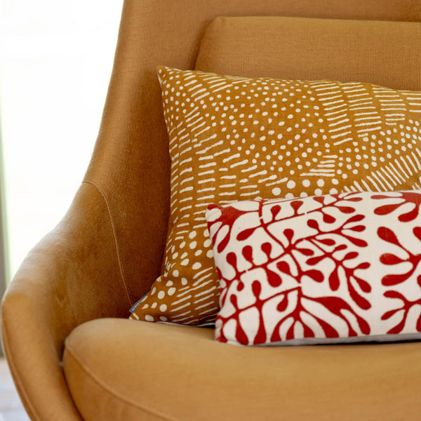 Patterned cushions on a brown armchair