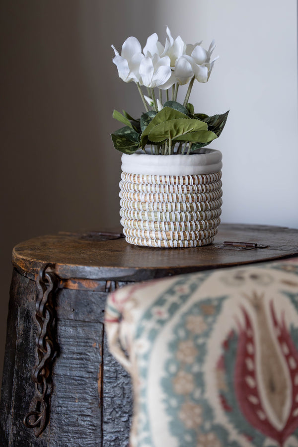 Decorative woven basket with white flowers on a wooden surface