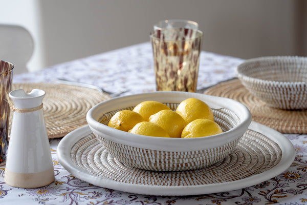 Bowl of lemons on a table with decorative items