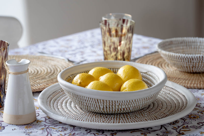 Bowl of lemons on a table with decorative items