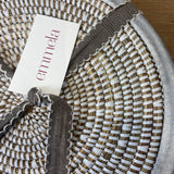 handwoven white placemat with brushed silver trim and emmela label