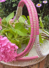 Handwoven pink and white trug basket with flowers